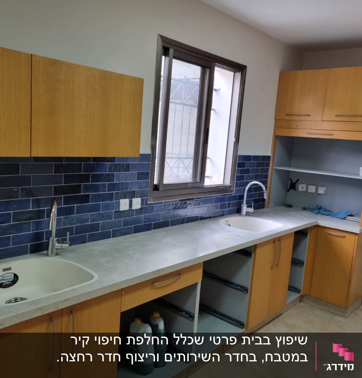 מטבח בשיפוץ עם ארונות עץ, כיורים וברזים חדשים